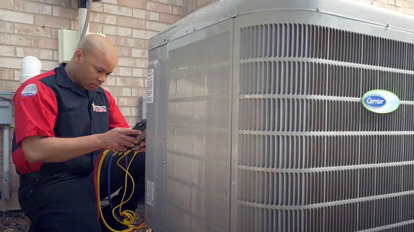 A King technician checking an outdoor AC condenser