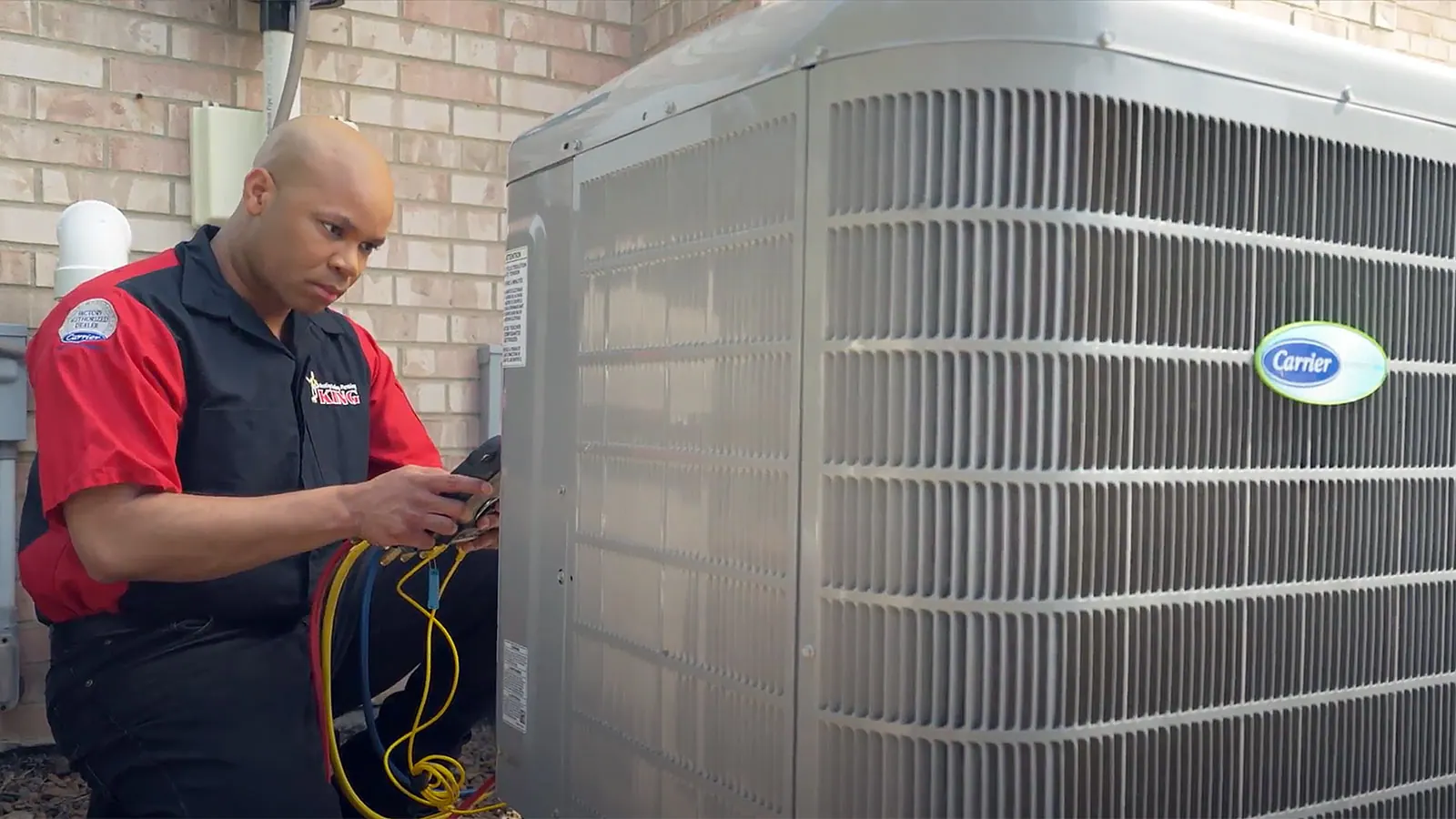 A King technician working on an outdoor AC condenser