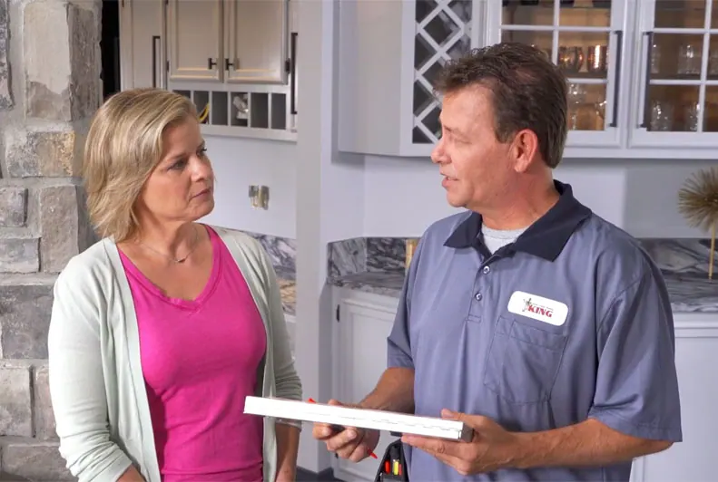 A King technician reviewing an AC unit with a homeowner