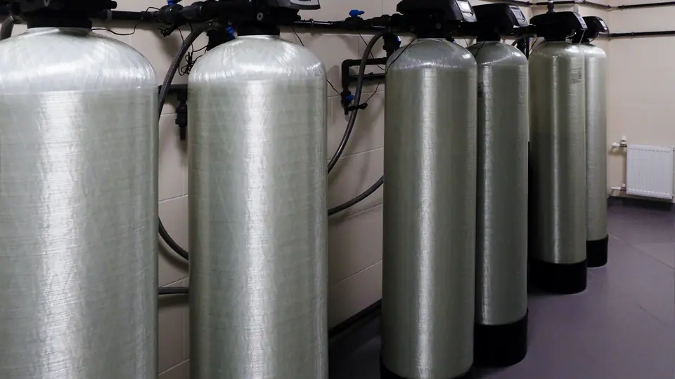 Salt-based water softener resin tank and brine tank installed in a home