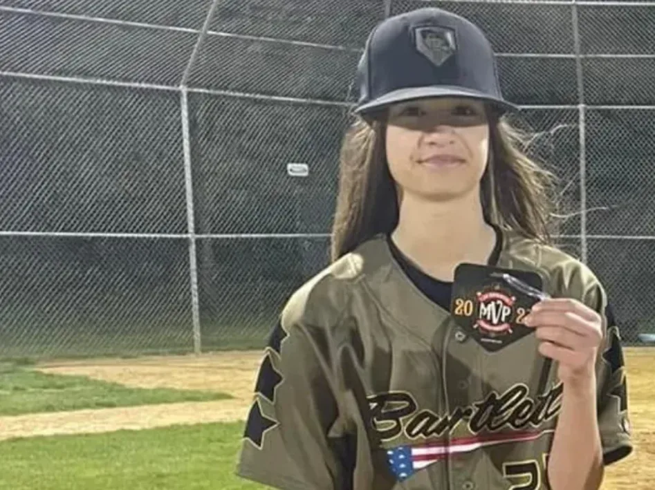 Madlin "Cookie" Cerny holding an MVP medal on the baseball field