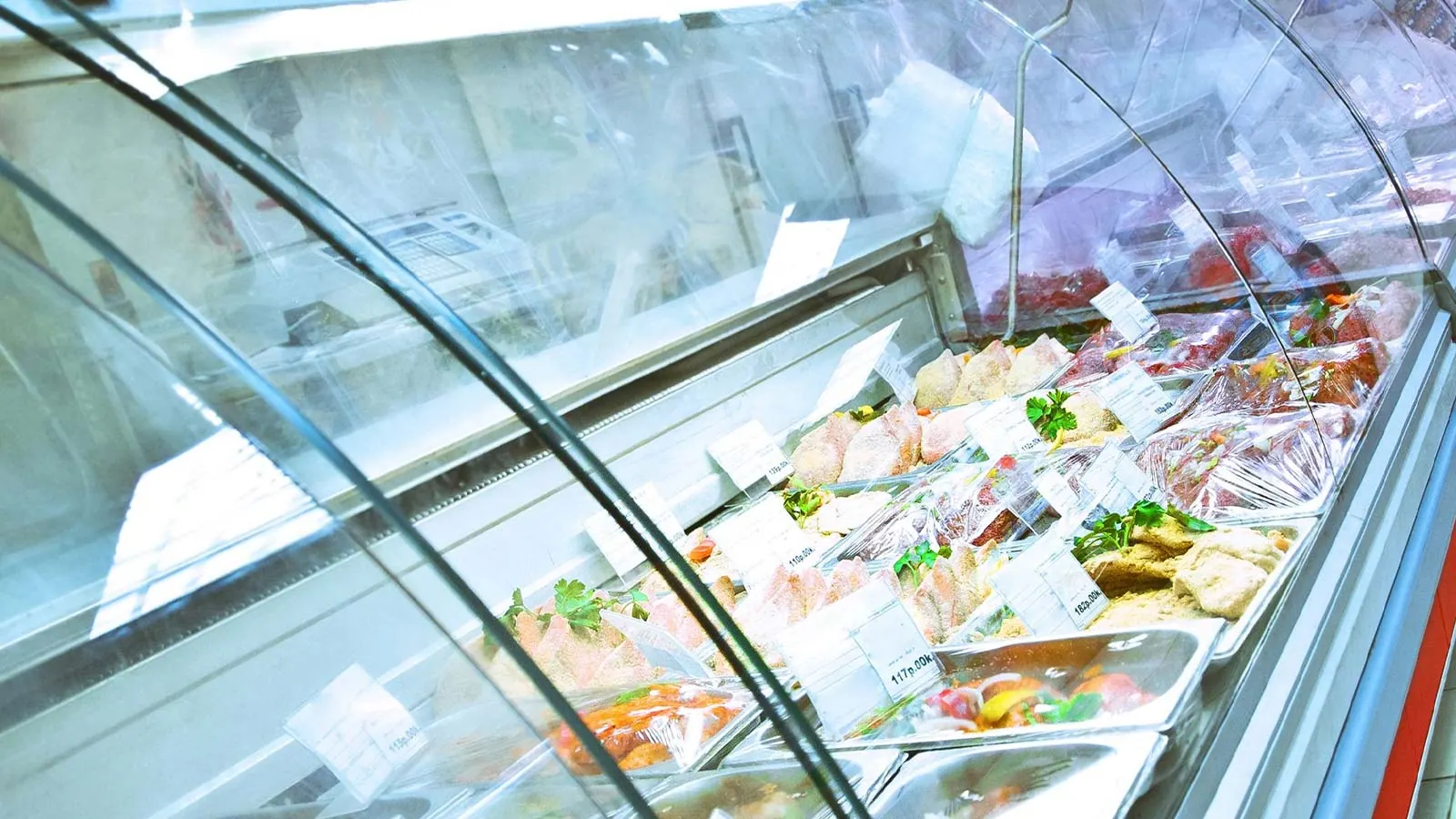 A refrigerated deli display case stocked with food