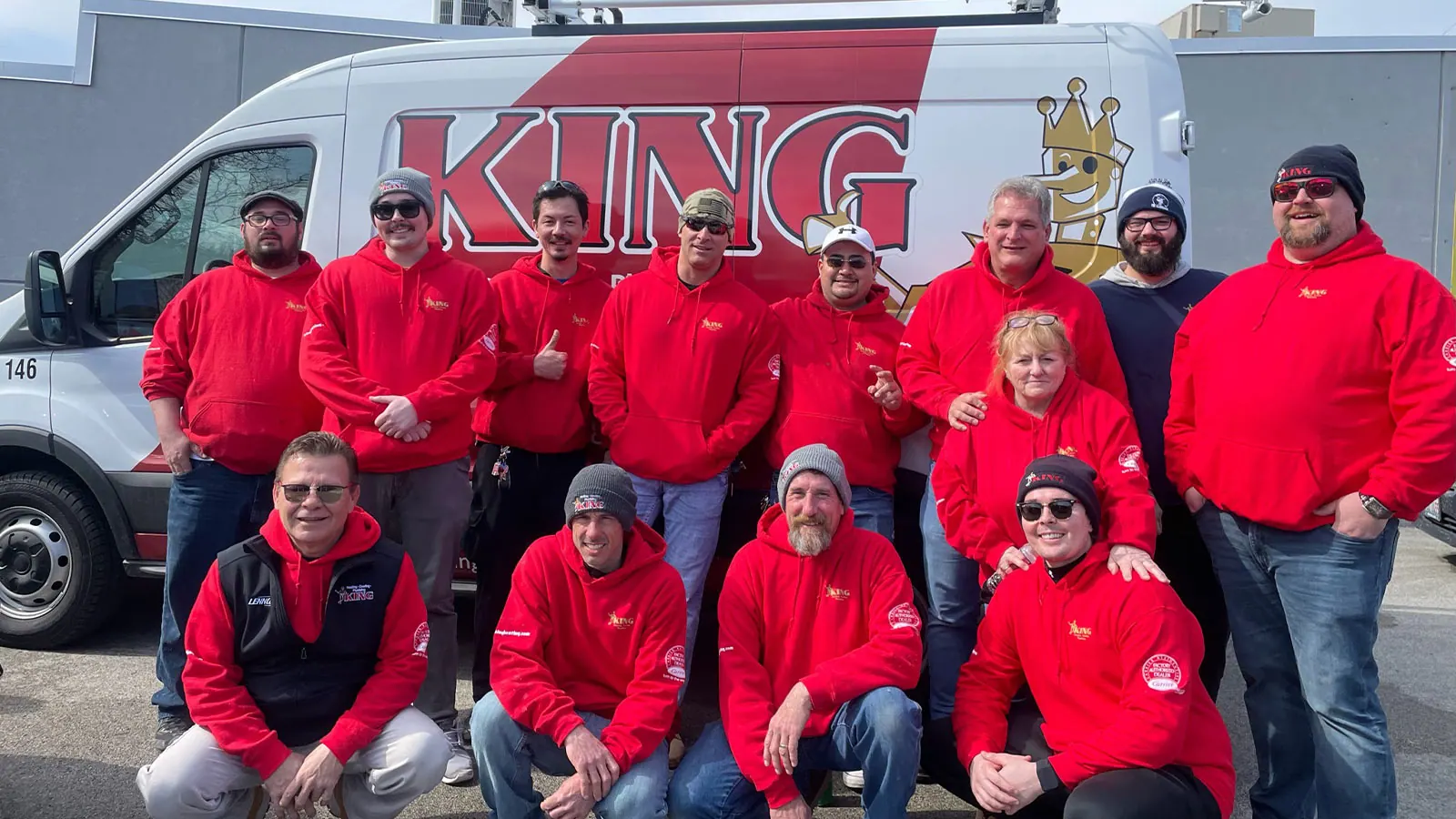 The King team in red jackets in front of King service vans