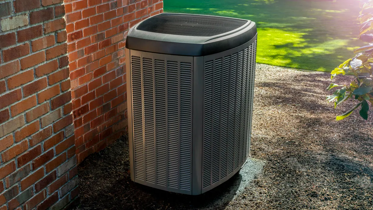 An outdoor heat pump unit beside a home