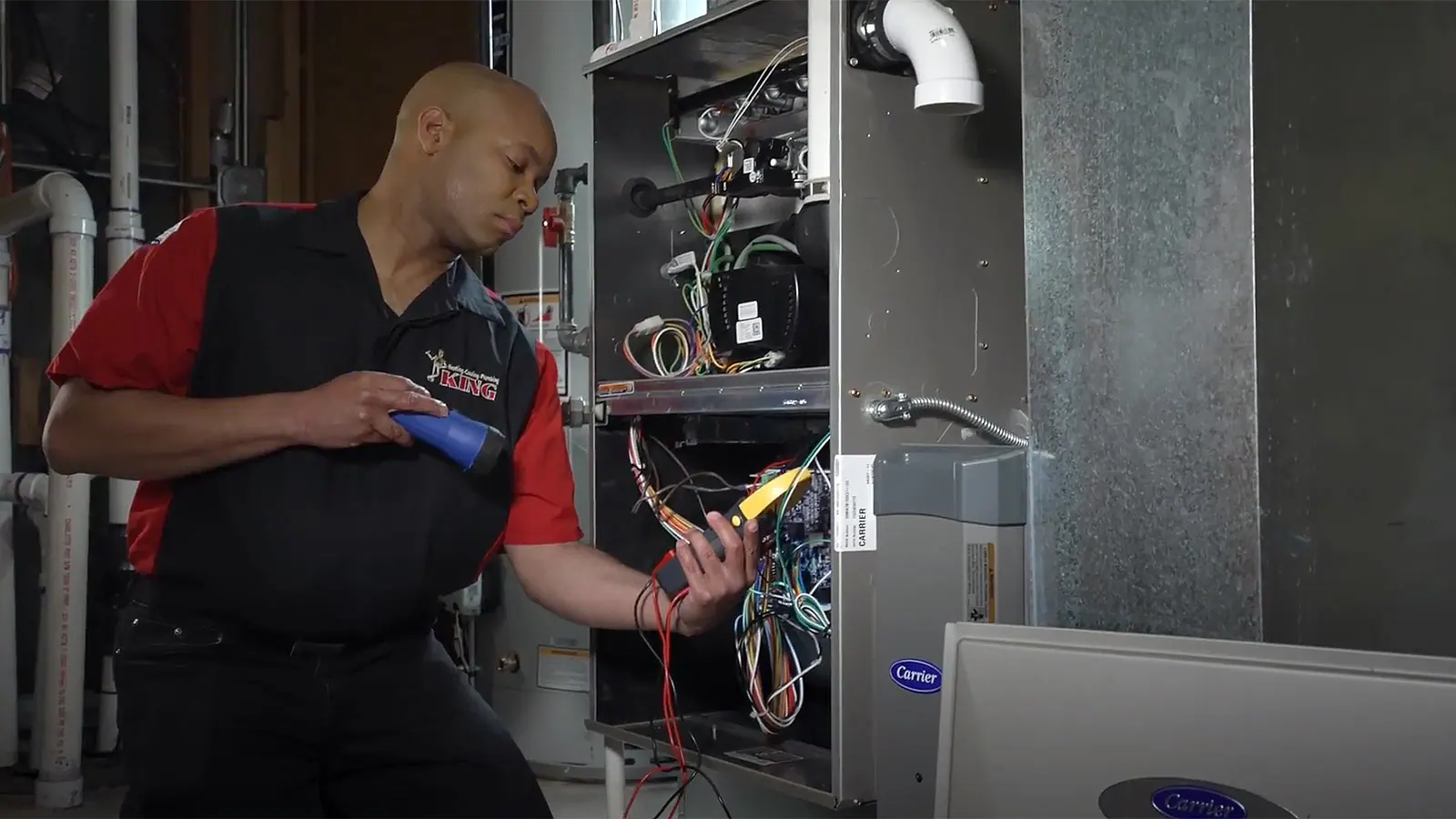 A King technician working inside an open furnace while the homeowner watches