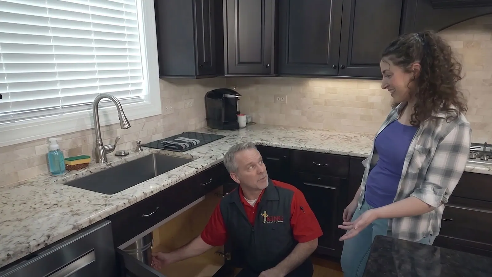 A King plumber repairing a kitchen sink