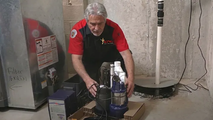 A King plumber replacing a basement sump pump