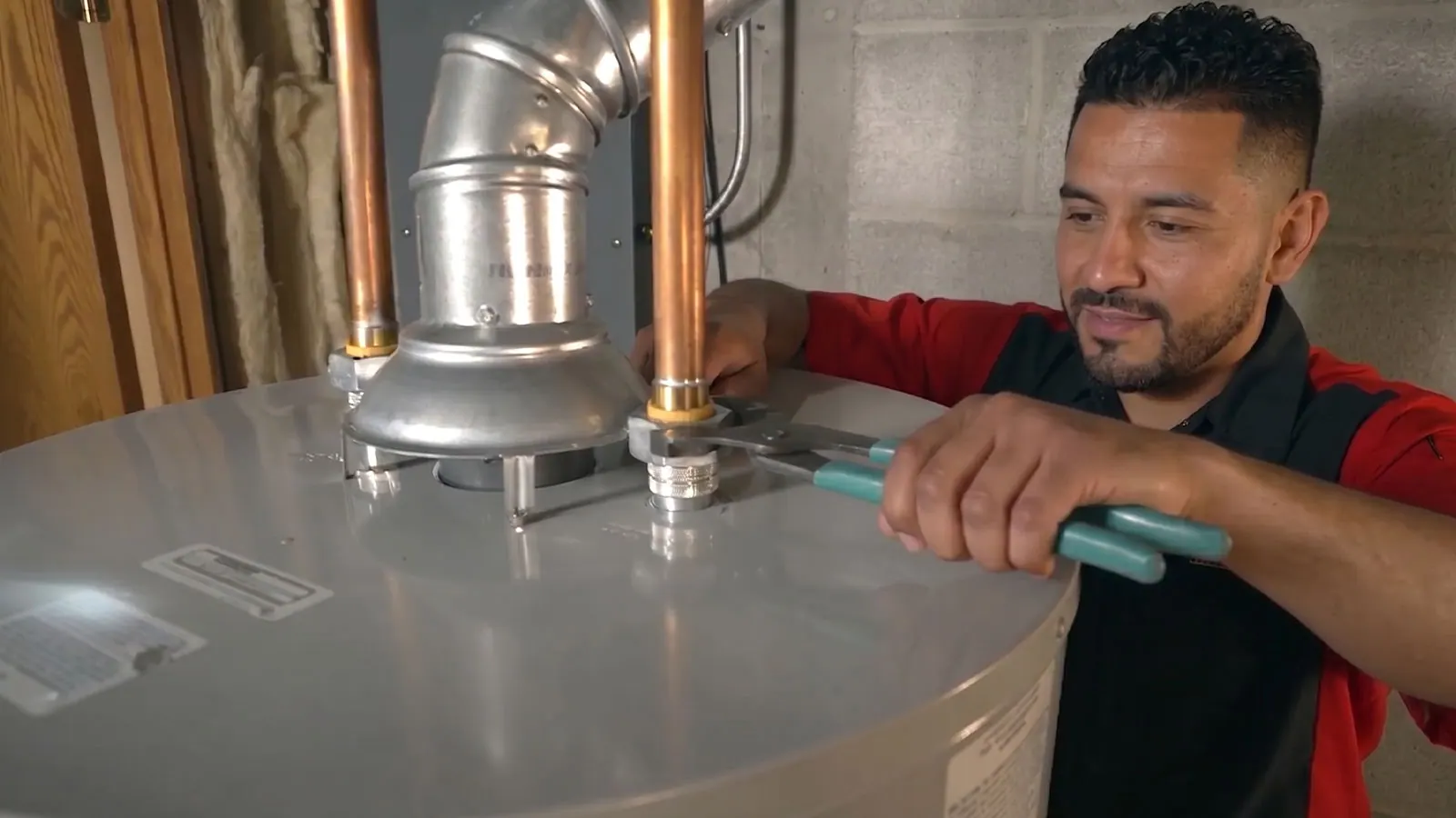 A King plumber repairing a tank water heater