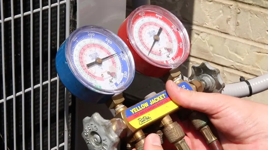 Refrigerant gauges connected during an AC repair