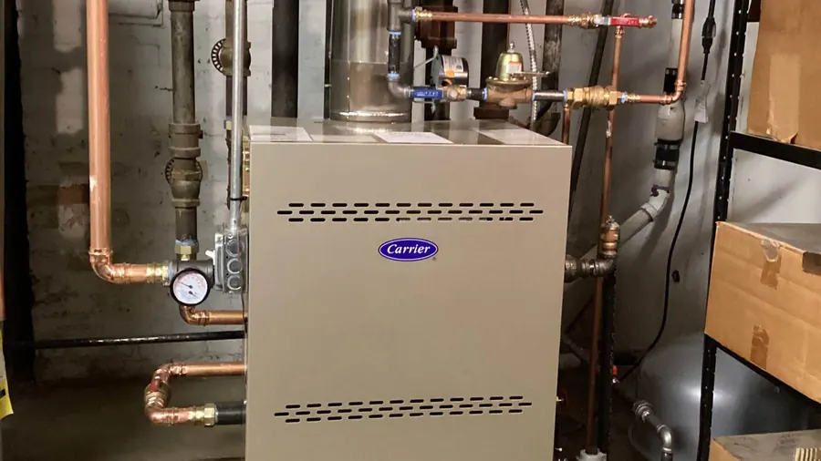 A Carrier boiler with copper piping installed in a basement