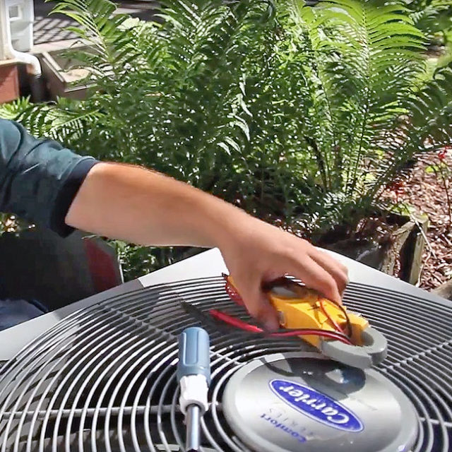 Using specialized equipment, a King technician performs seasonal maintenance on a local AC unit here in Chicago, IL