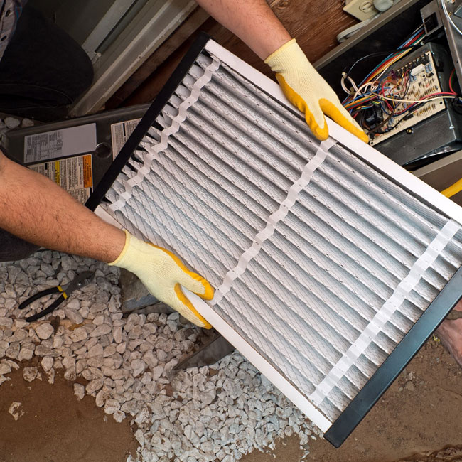 A King technician visually inspects a furnace filter after cleaning it, ensuring that it's ready to protect the furnace.