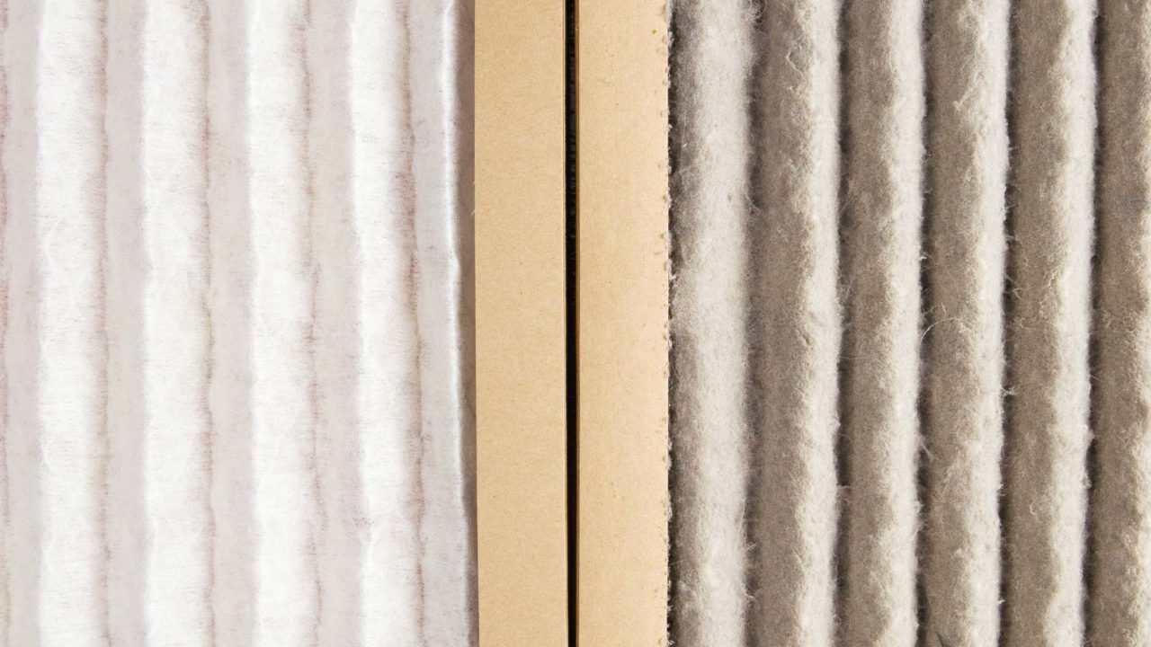 A King technician displays a dirty HVAC air filter (right) side-by-side with a clean HVAC air filter (left).
